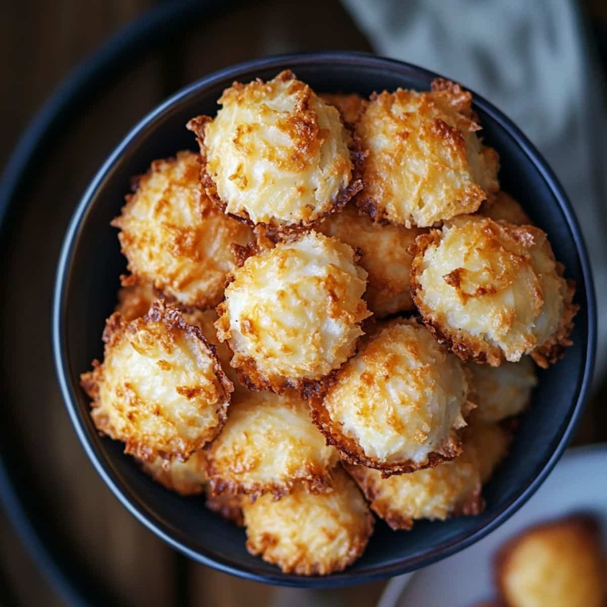 A batch of freshly baked Macaroons No Almond Flour, golden brown and slightly crispy on a white kitchen counter.