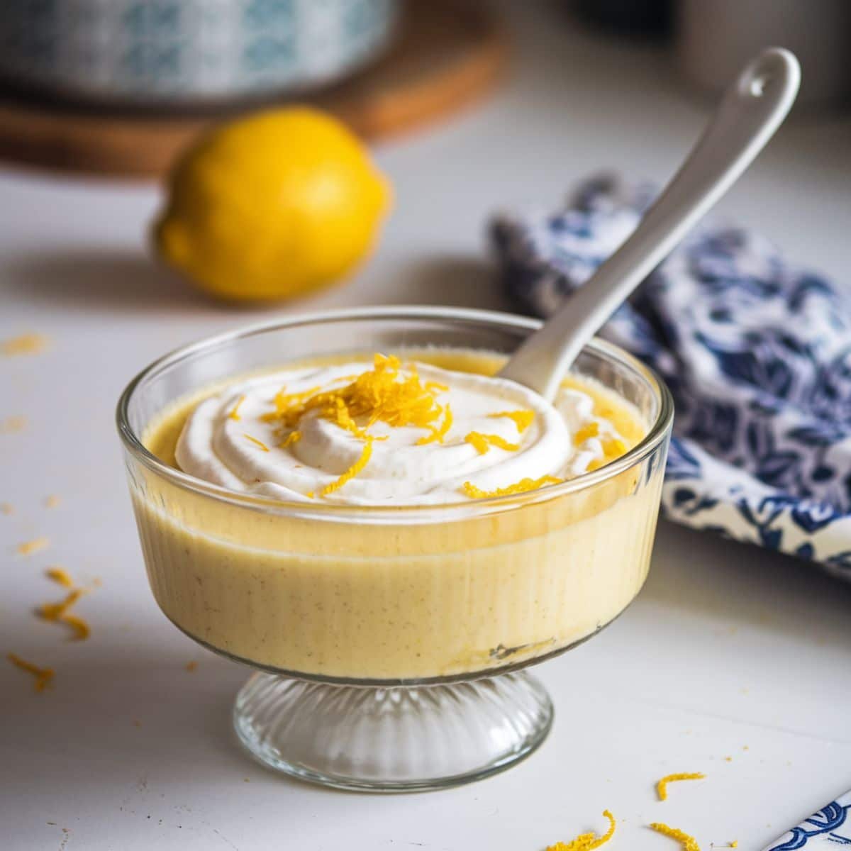 Jar of creamy homemade lemon cake filling with lemon zest on top.