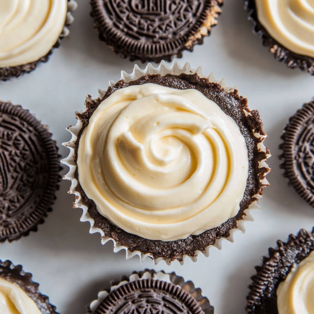 Spooning Oreo cheesecake filling into prepared crusts	