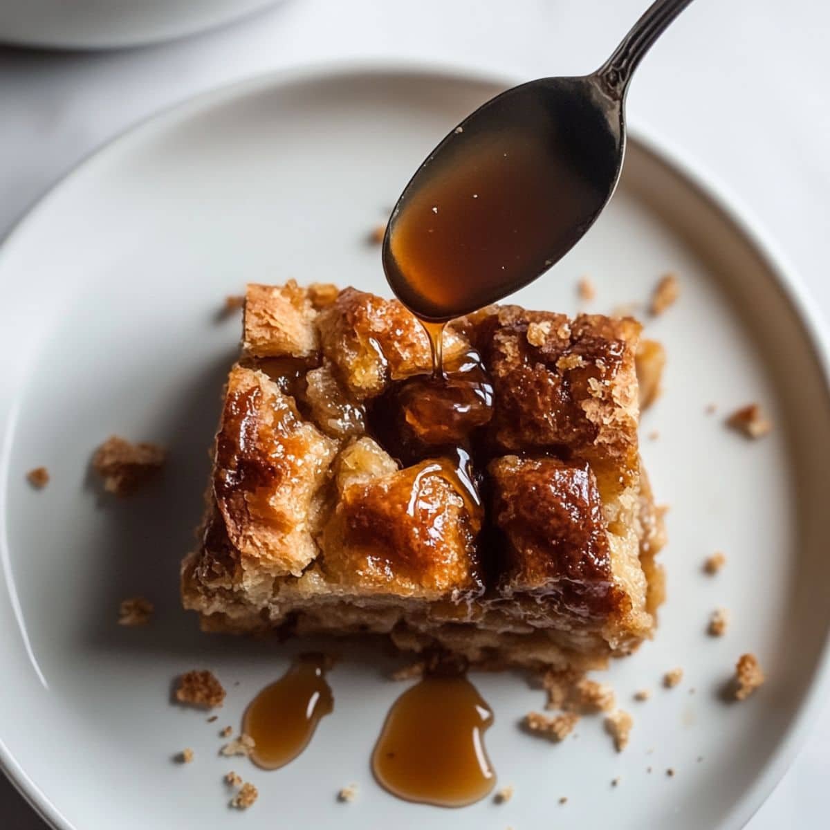 Croissant Bread Pudding slice served with caramel sauce.	
