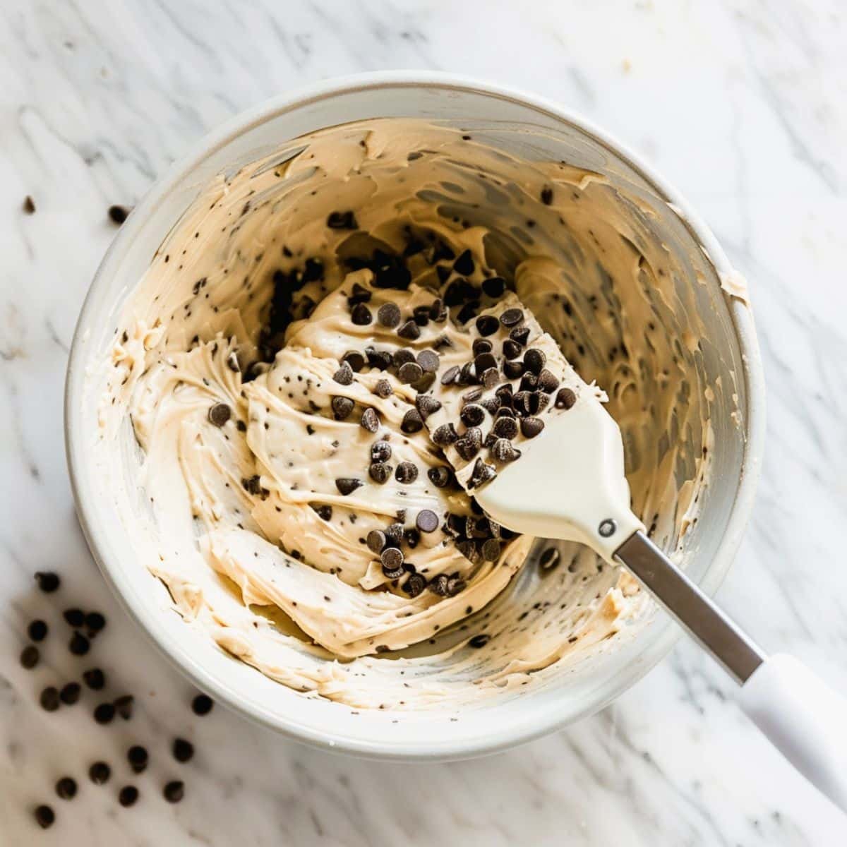 Mixing muffin batter in a bowl with chocolate chips	