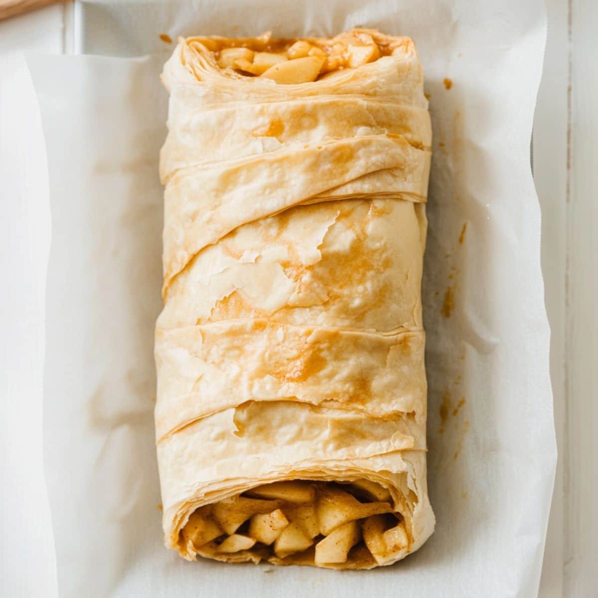 Rolled apple strudel on tray before baking	