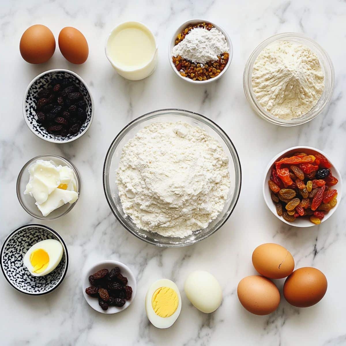 Raw empanadas recipe ingredients; flour, meats, vegetables, and spices—scattered casually on a white kitchen counter.