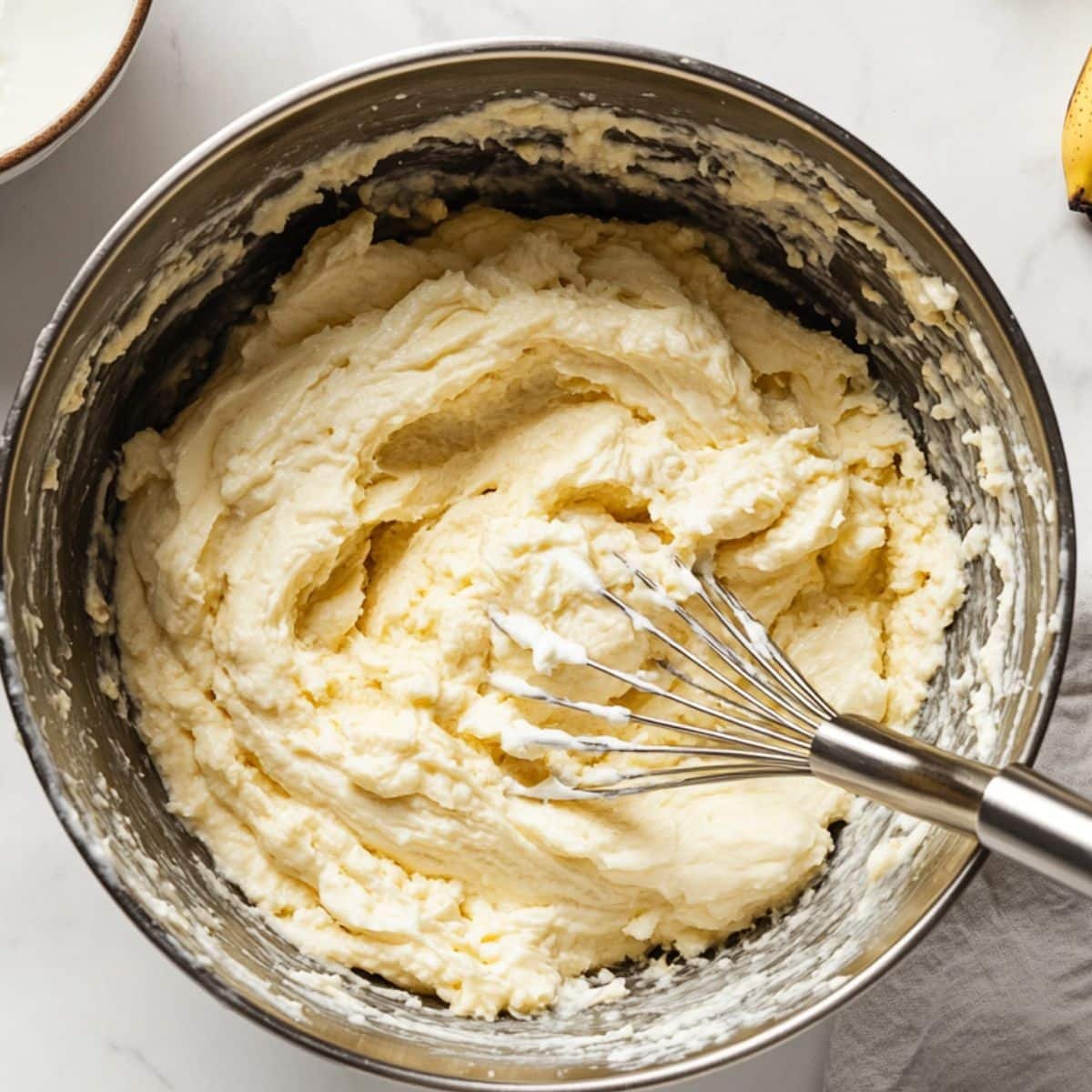 Whisking banana cake batter ingredients together in a large bowl	