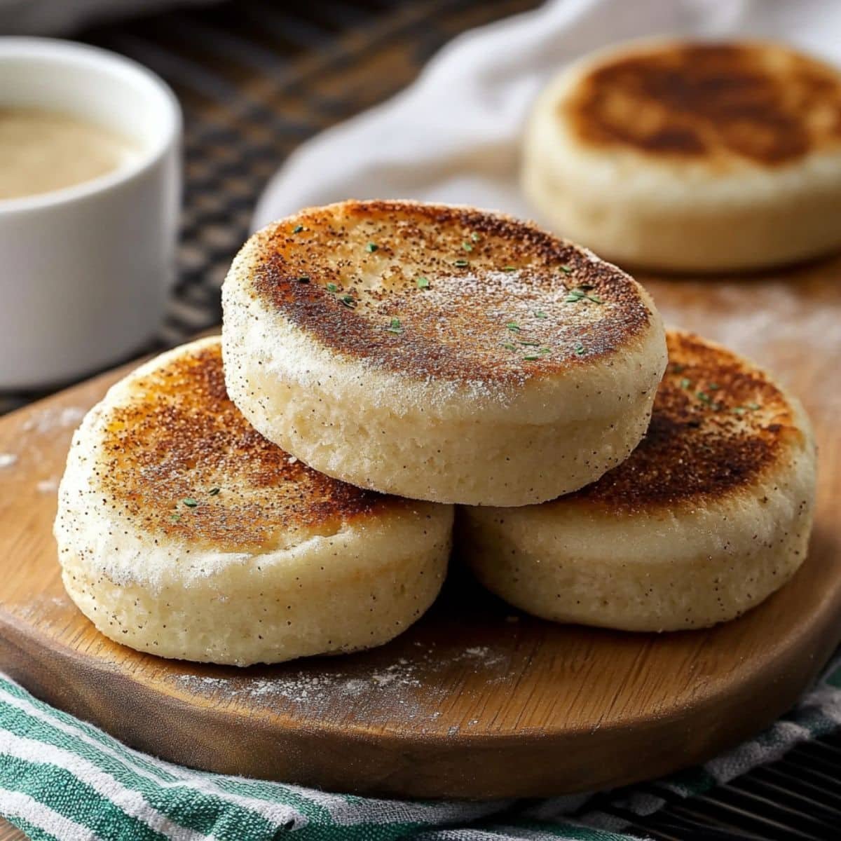 Homemade gluten-free English muffins on a white kitchen counter, showing texture and soft, rustic appearance