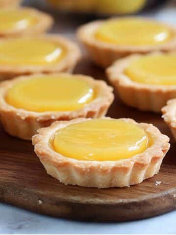 Close-up of homemade mini lemon tarts on a white kitchen counter