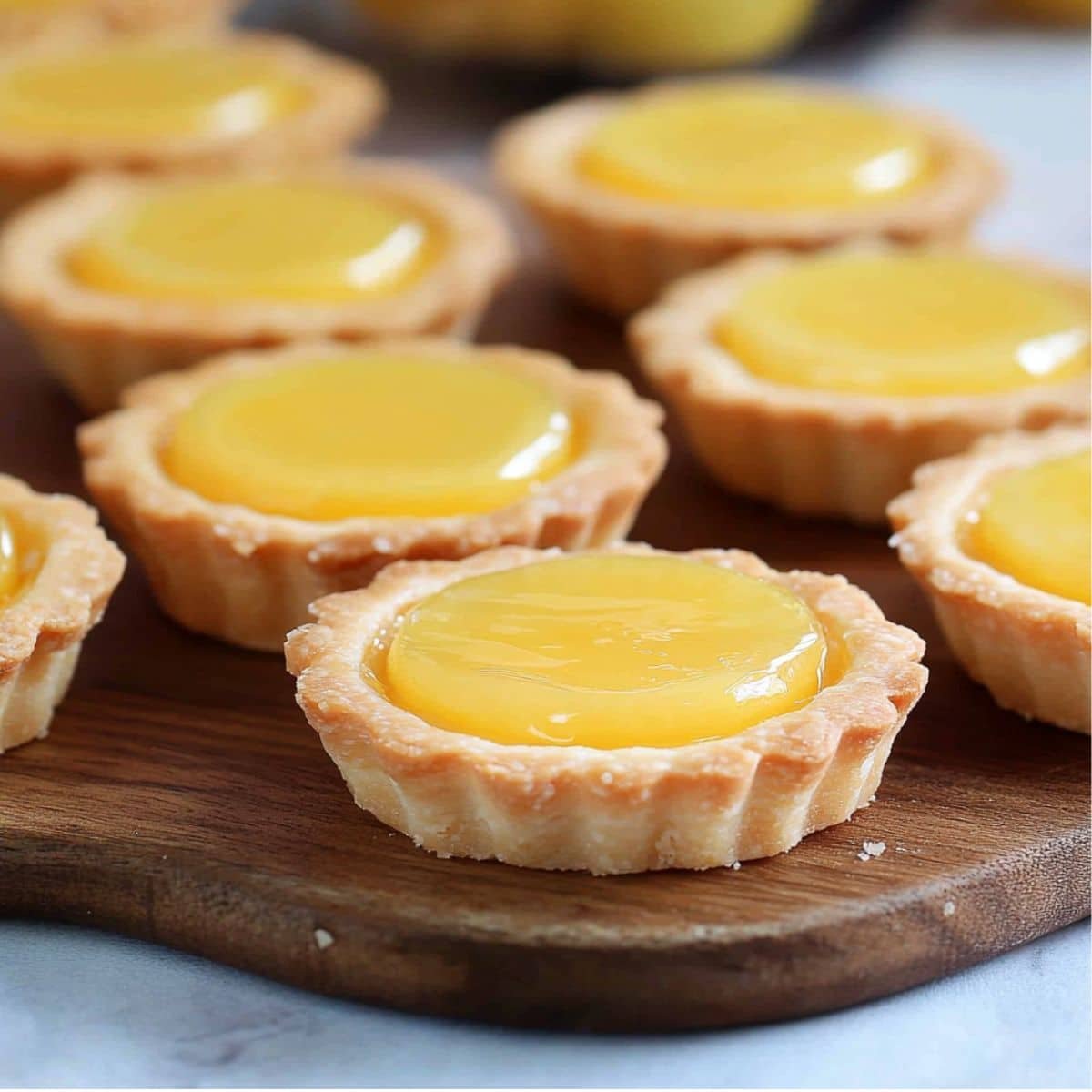 Close-up of homemade mini lemon tarts on a white kitchen counter	