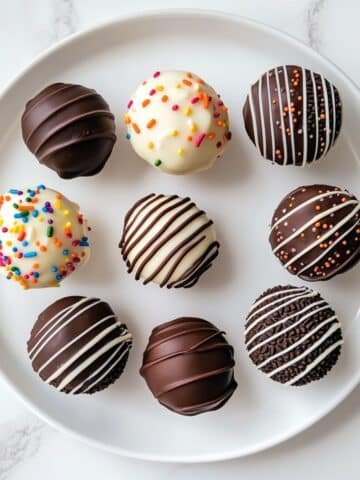 Homemade Oreo cake pops dipped in white chocolate with chocolate drizzle