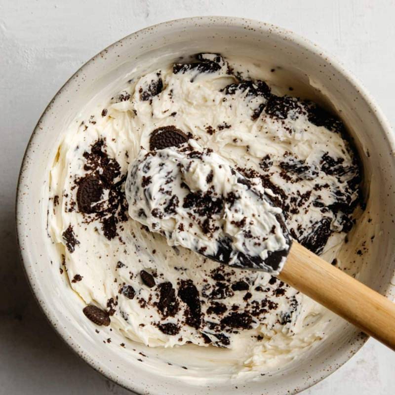 Crushed Oreos mixed with cream cheese in a bowl	