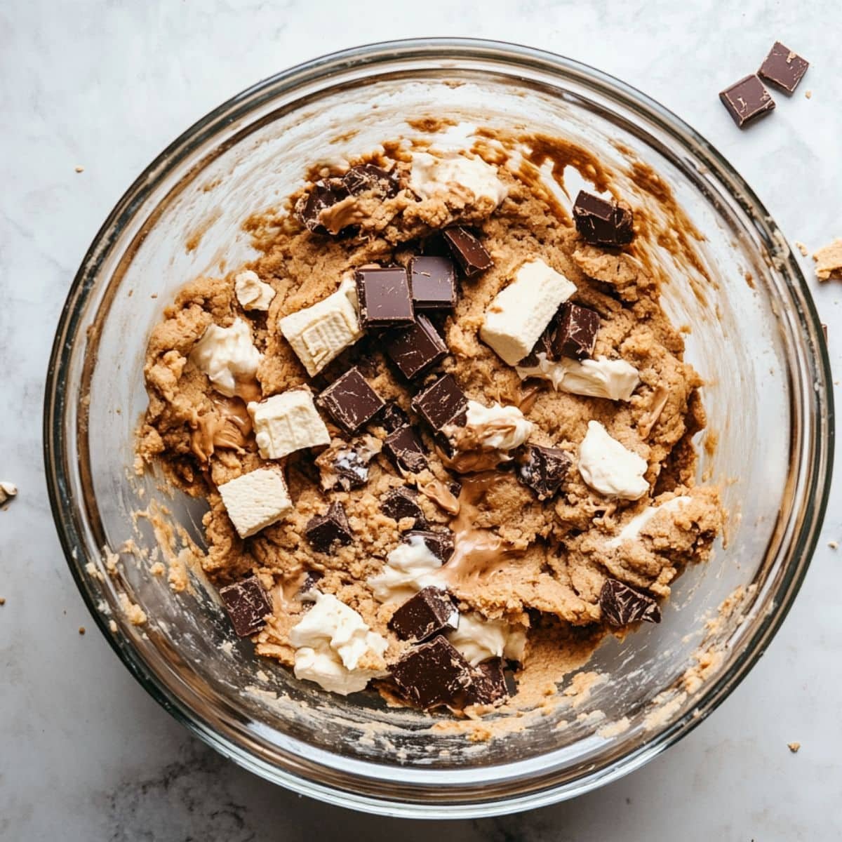 Cookie dough being mixed with chocolate chunks and graham crackers.	