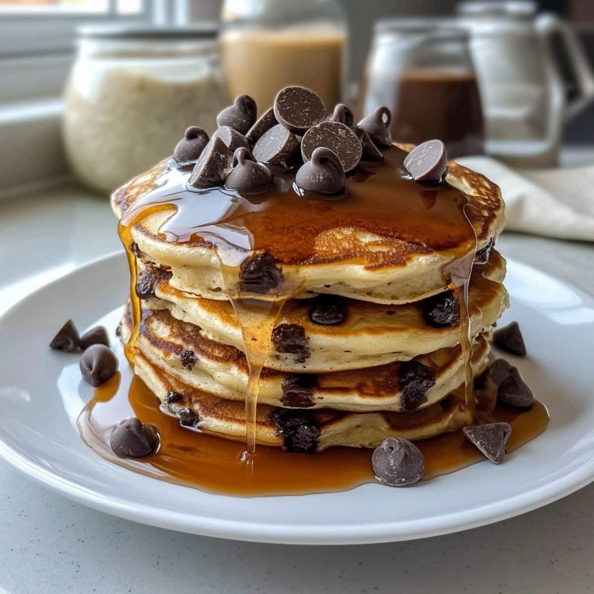 Stack of homemade chocolate chip pancakes with syrup and butter on top	