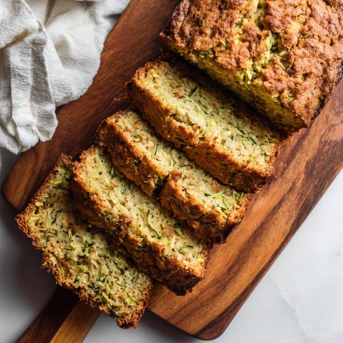 Freshly sliced keto zucchini bread on a wooden board
