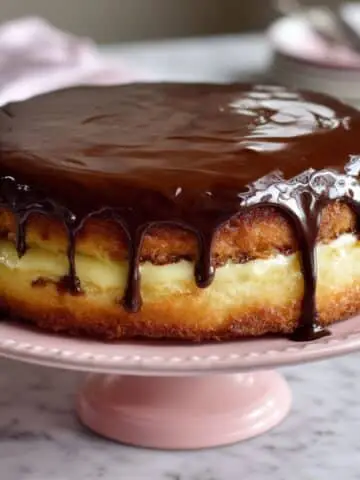 Boston Cream Pie with rich chocolate glaze and custard filling on cake stand