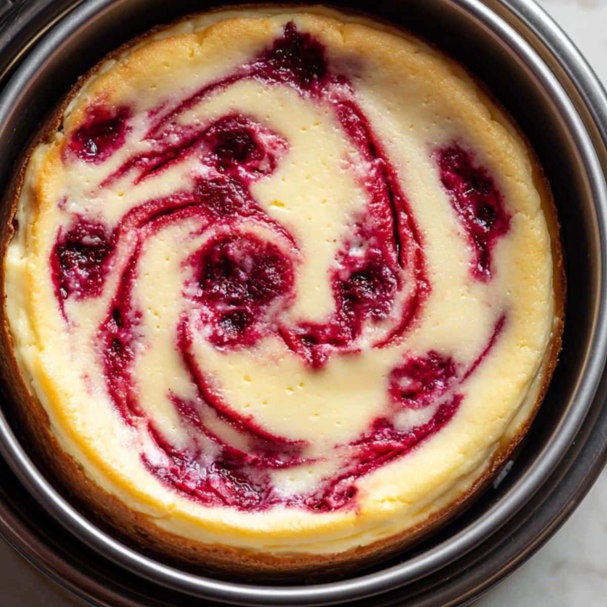 Cheesecake with raspberry swirl cooling 