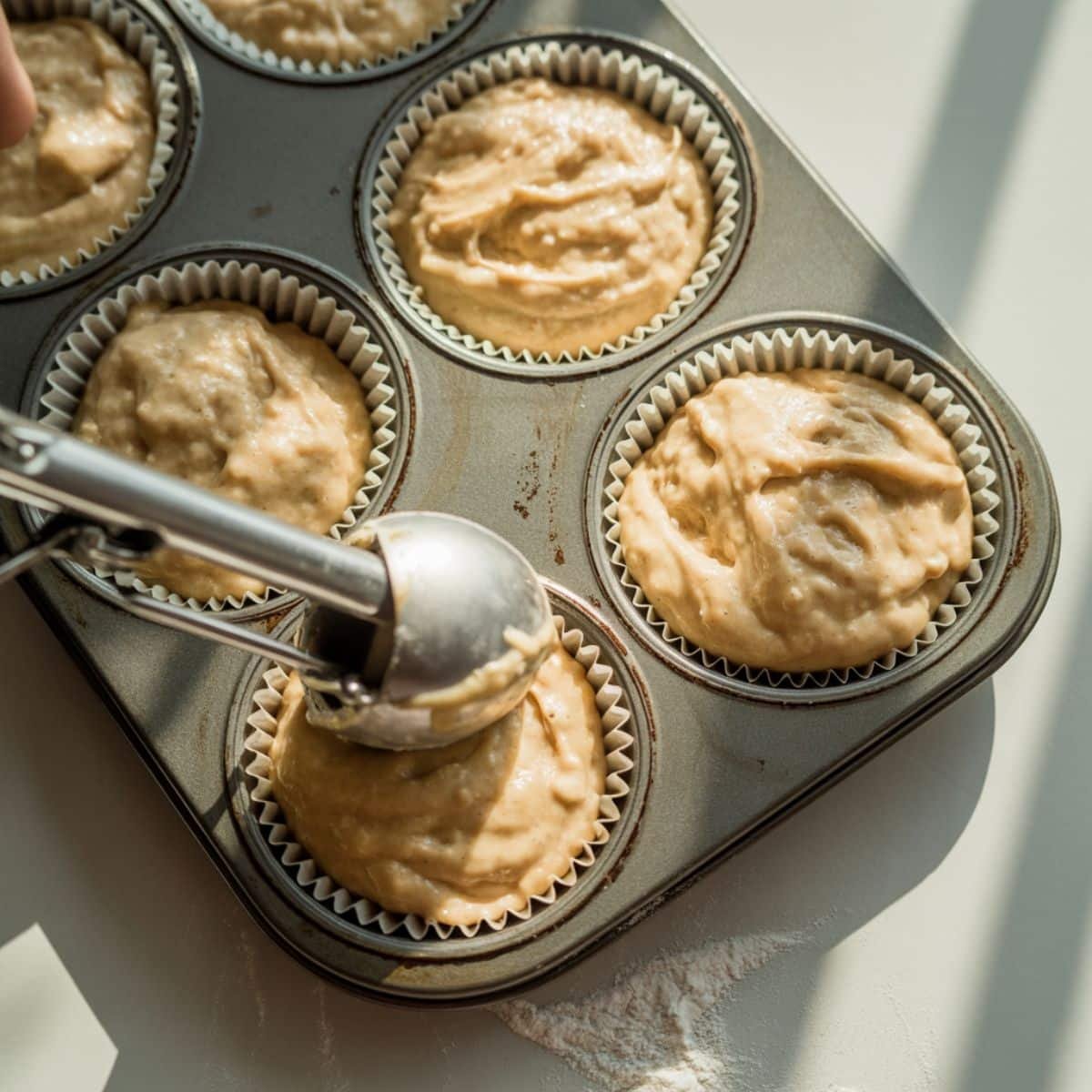 Gently fold and portion batter into muffin cups.
