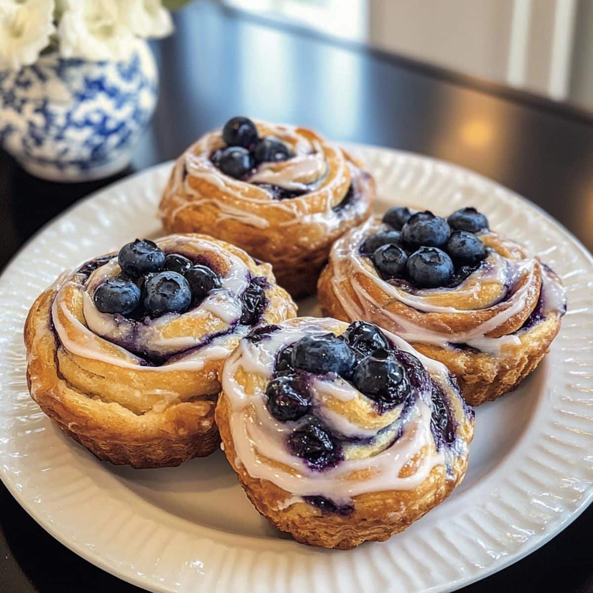 Overhead view of golden blueberry cruffins recipe on a kitchen counter with scattered fresh blueberries	