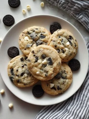 Soft cookies and cream cookies with Oreo chunks and white chocolate chips on parchment paper