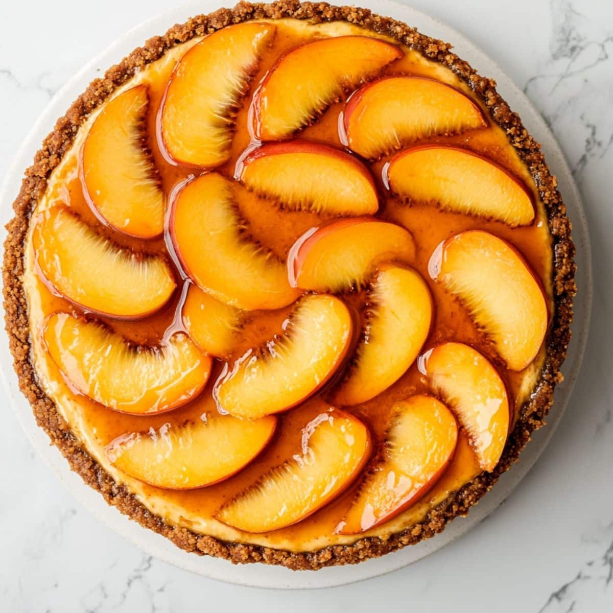 Homemade peach cheesecake recipe topped with fresh glazed peach slices	