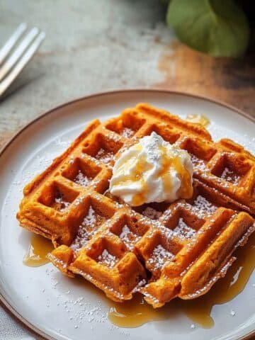 Stack of sweet potato waffles with butter and syrup