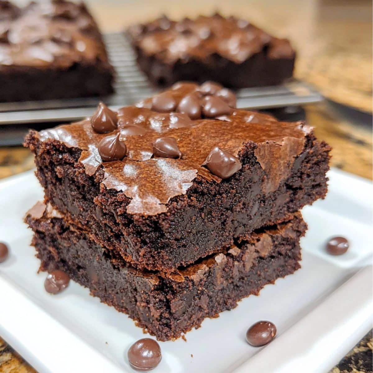 Homemade black bean brownies with chocolate chips on a white kitchen counter	