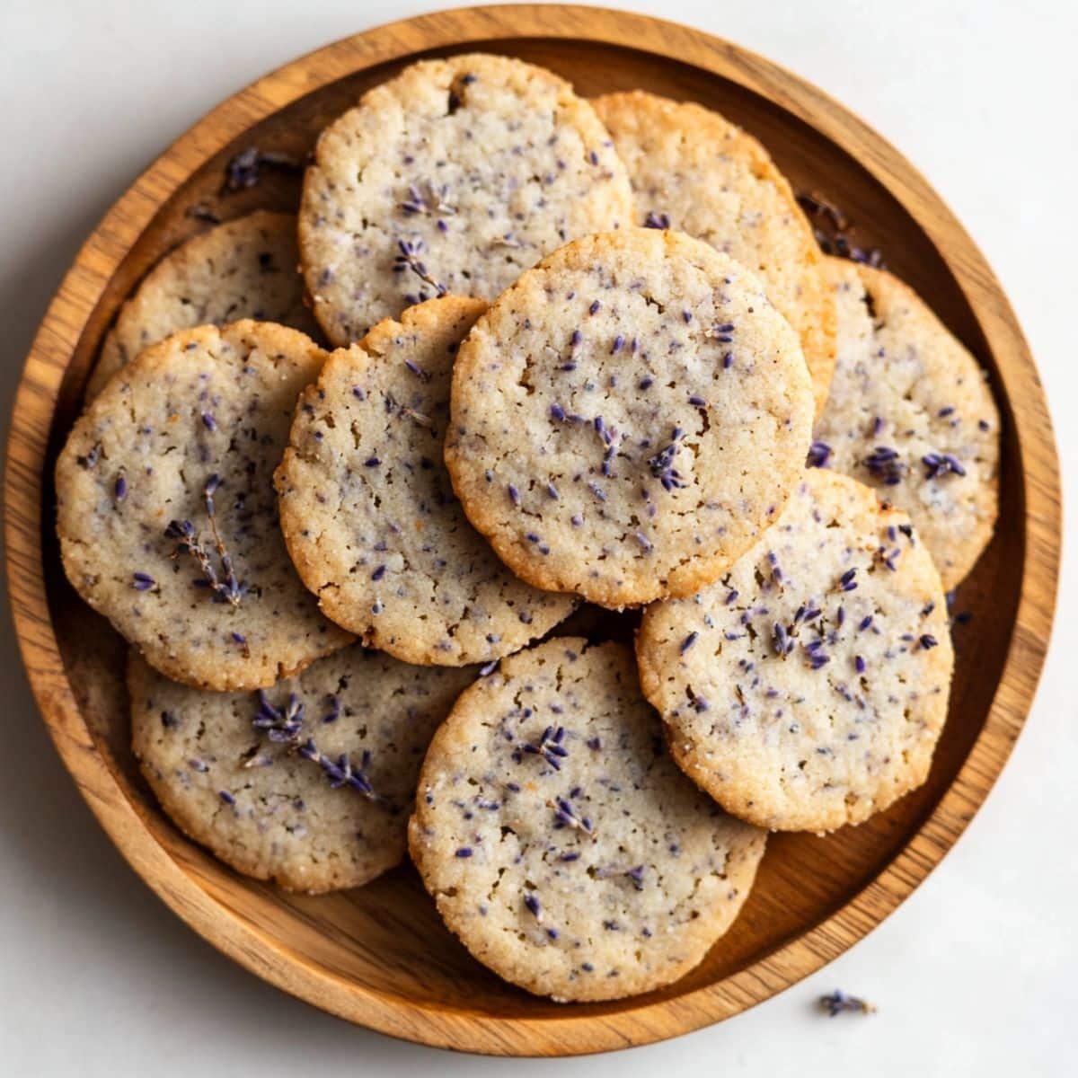 Homemade Lavender Cookies Recipe on wood plate with rustic texture and edible flower garnish	