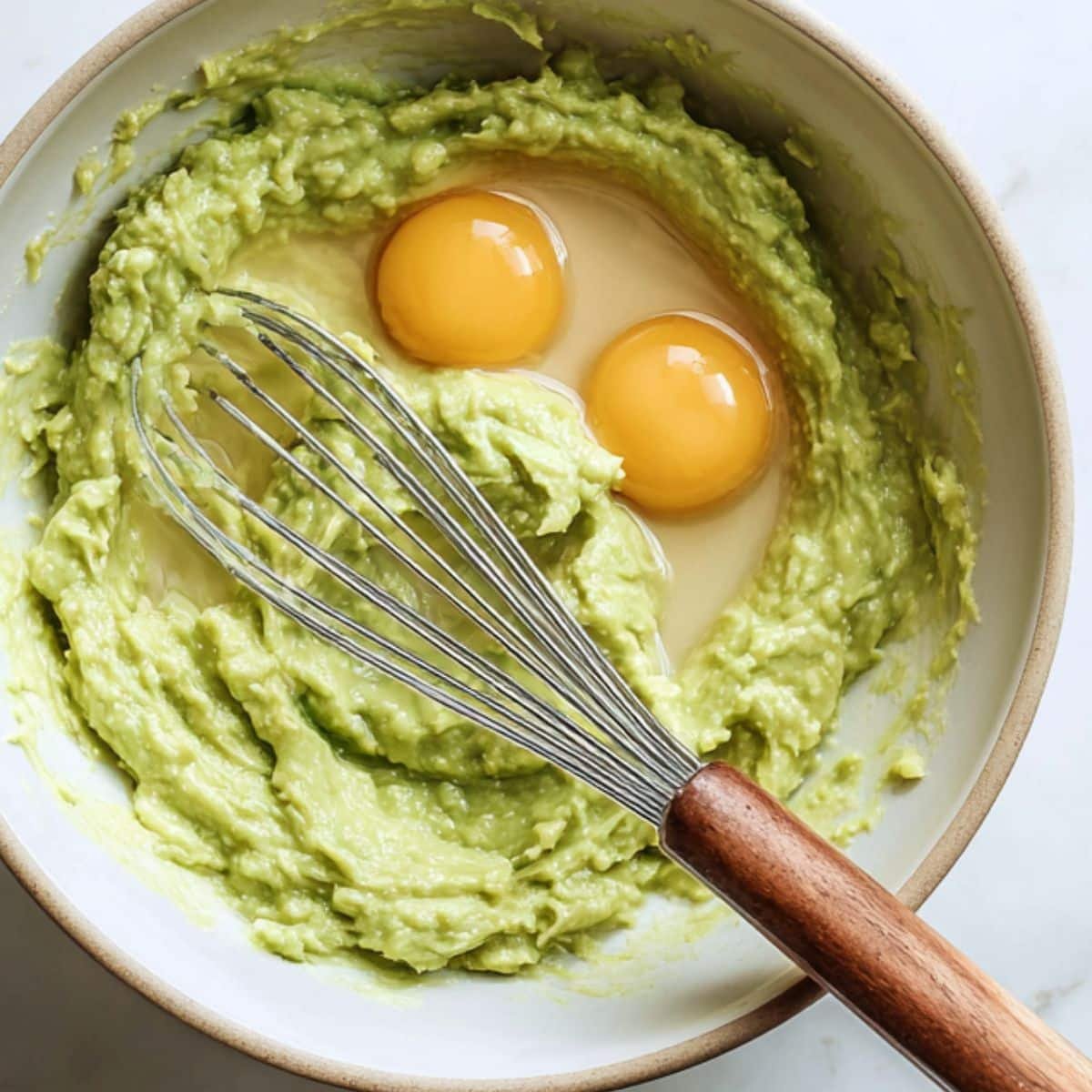 Mashing avocados and mixing wet ingredients in a bowl	