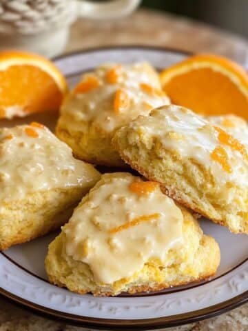 Homemade orange scones recipe with glaze on a white plate