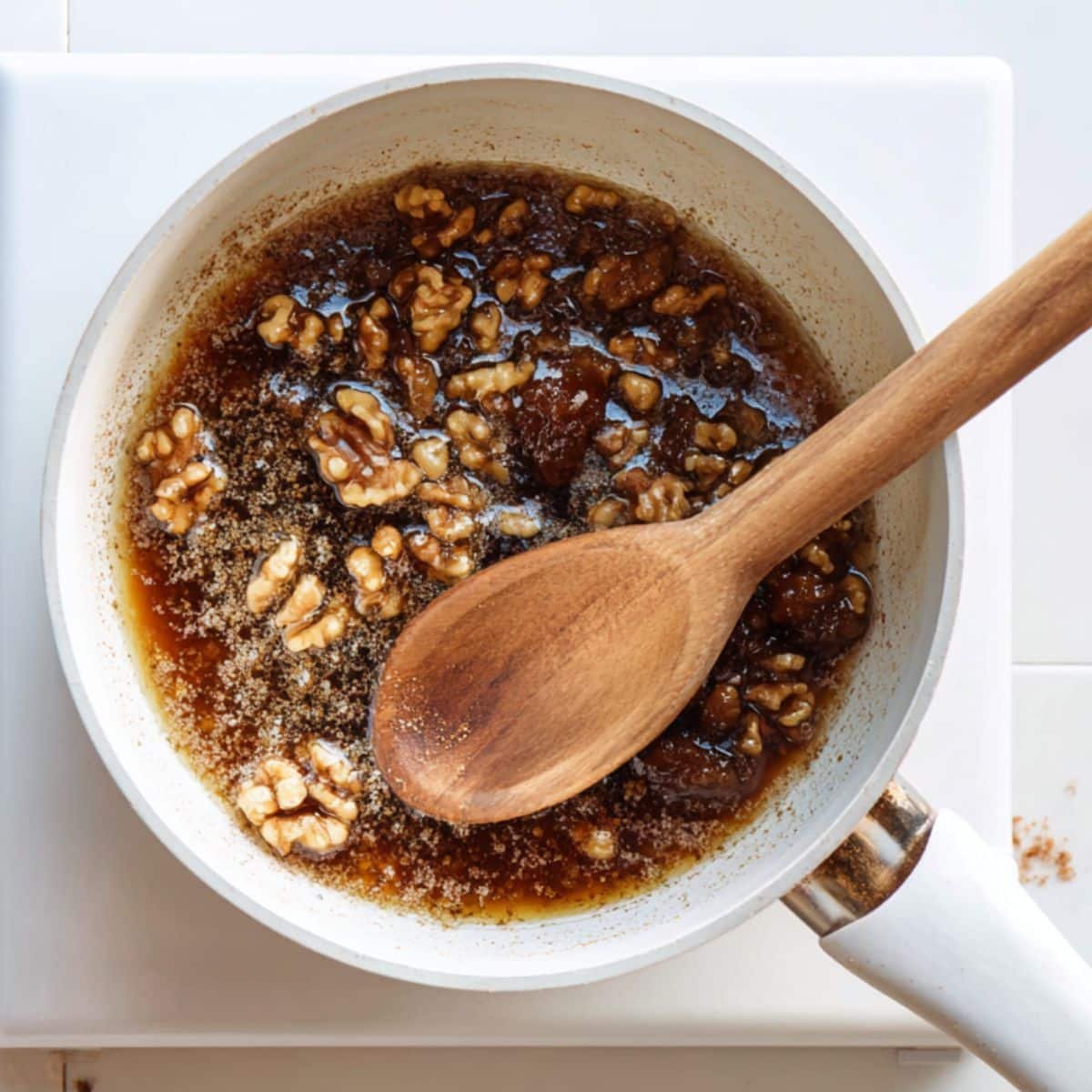 Chopped dates simmering with cinnamon and walnuts in a small saucepan	