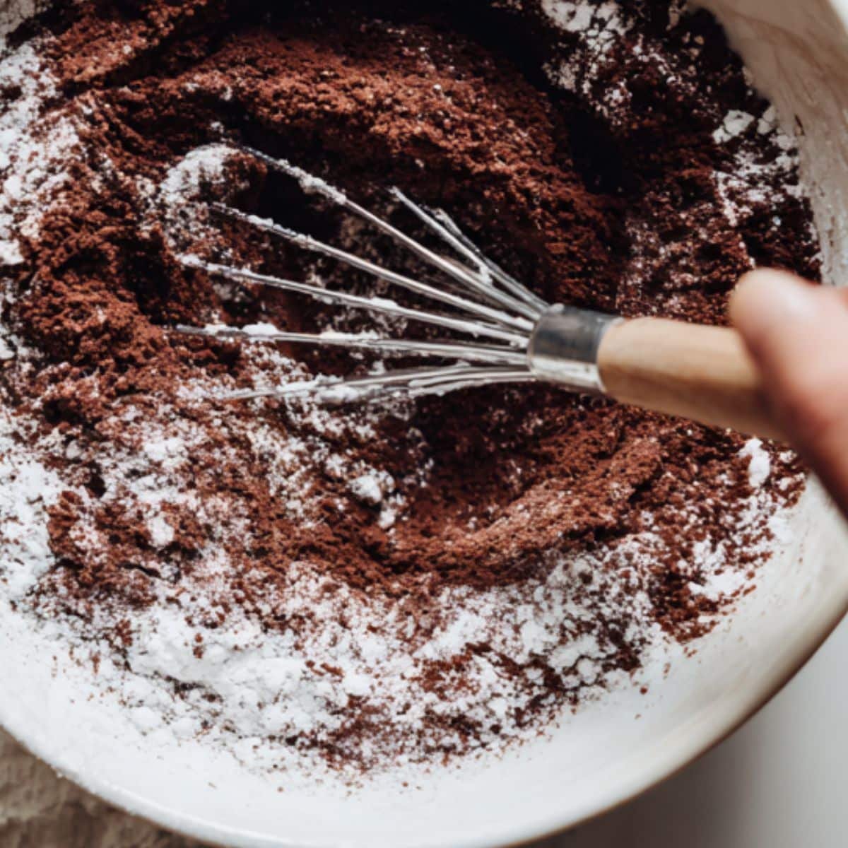 Stirring dry vegan brownie ingredients and prepping flax egg	