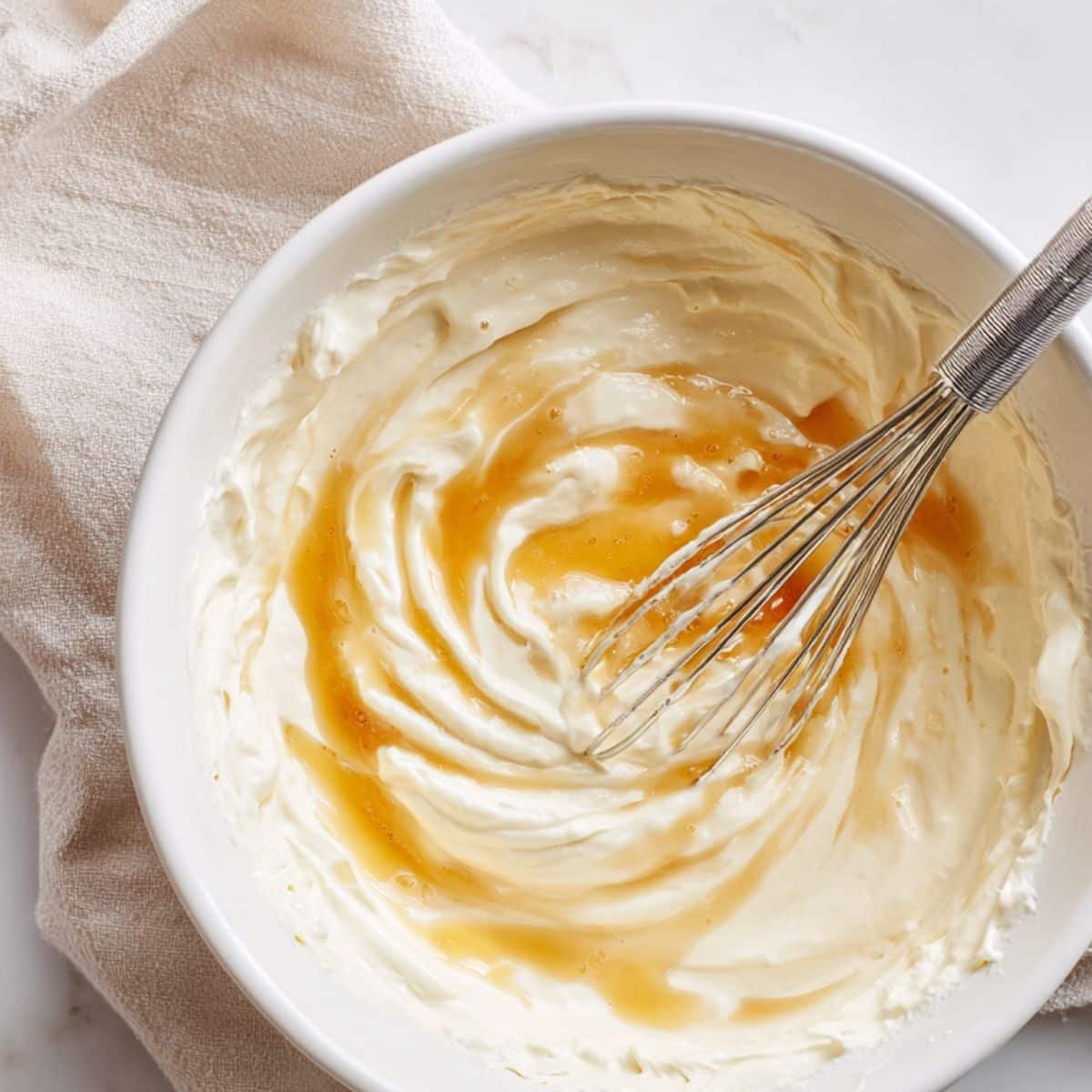 Mixing Greek yogurt, honey, and vanilla in a white bowl for frozen yogurt bark	