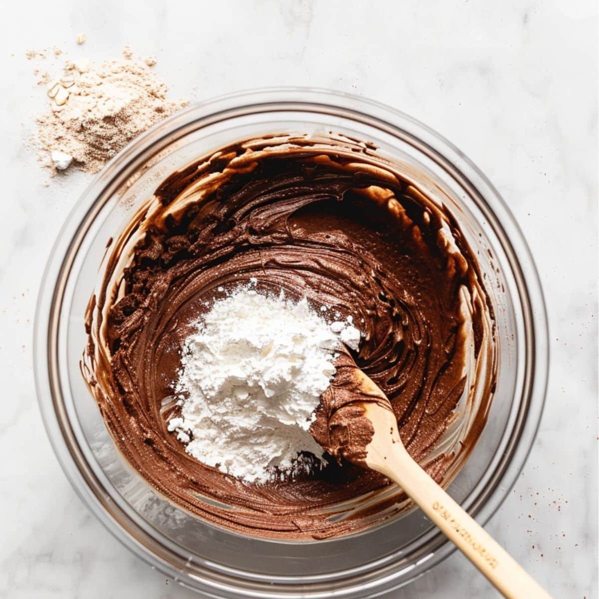 Folding cocoa and almond flour mix into blended wet brownie batter	