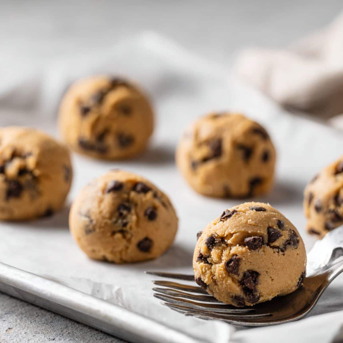 Scooped and flattened flourless cookie dough balls ready for baking