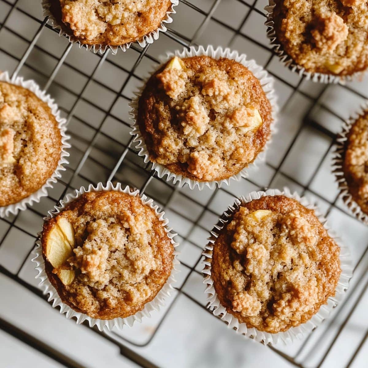 Freshly baked apple cinnamon oatmeal muffins cooling on wire rack	
