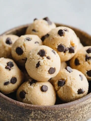 Homemade almond flour cookie dough balls in rustic bowl on white kitchen counter