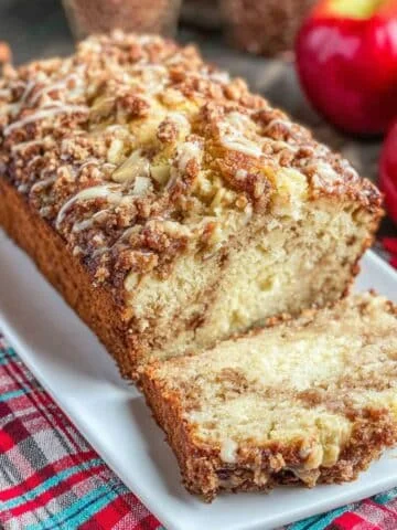 Sliced homemade apple pie bread on a white tray with cinnamon crust