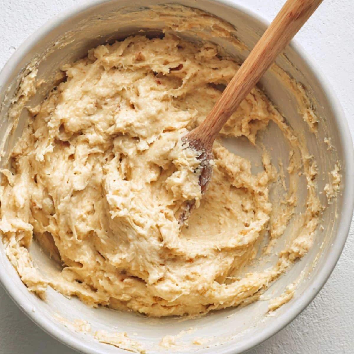 Apple pie bread batter being mixed in a white bowl	