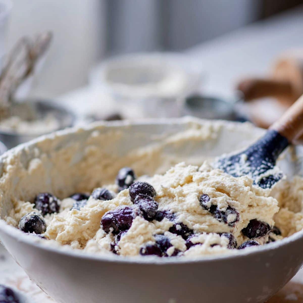 Mixing blueberry cake batter in a large bowl	