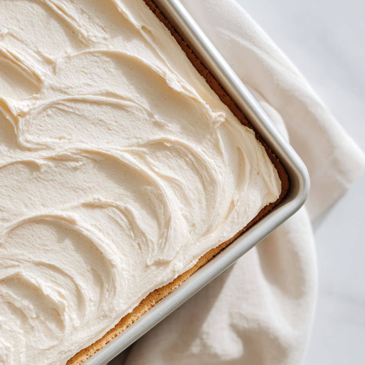 Spreading creamy cheesecake layer over the base	