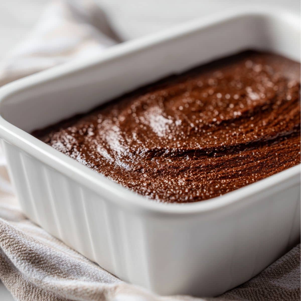Chocolate cake batter in a 9x13 inch white pan	