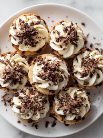 Close-up of a cookie cup topped with creamy frosting and chocolate shavings
