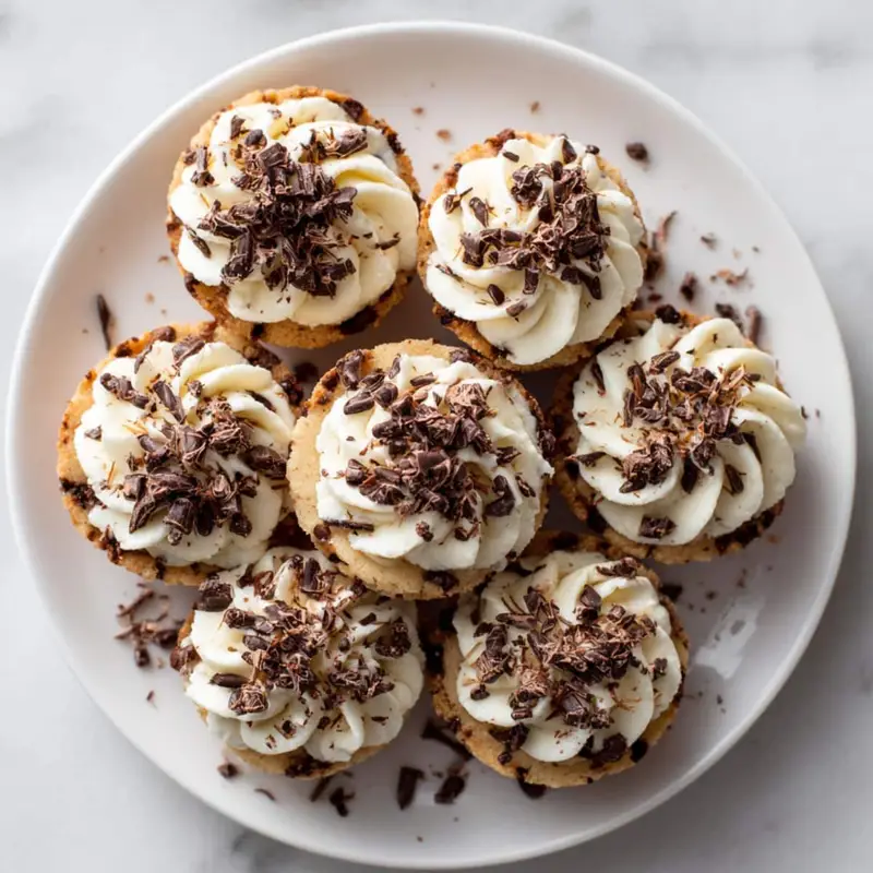 Close-up of a Cookie Cups Recipe topped with creamy frosting and chocolate shavings	