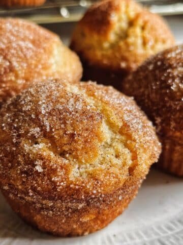 Close-up of cinnamon muffins on white plate sugar topping