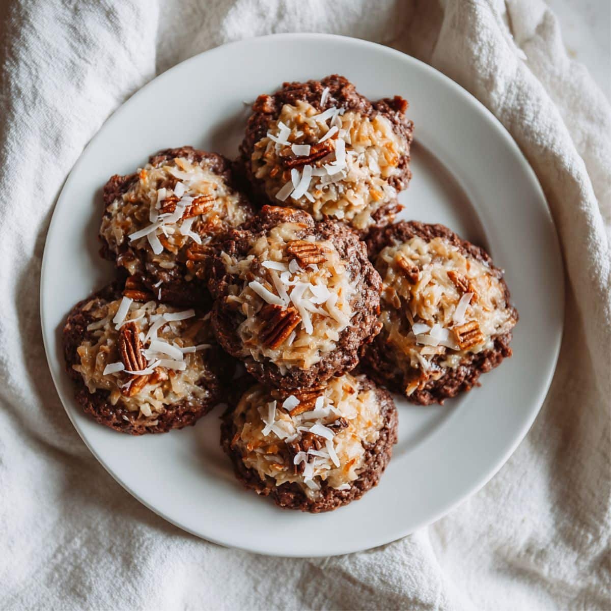 Homemade German Chocolate Cookies on white plate with gooey coconut pecan topping	