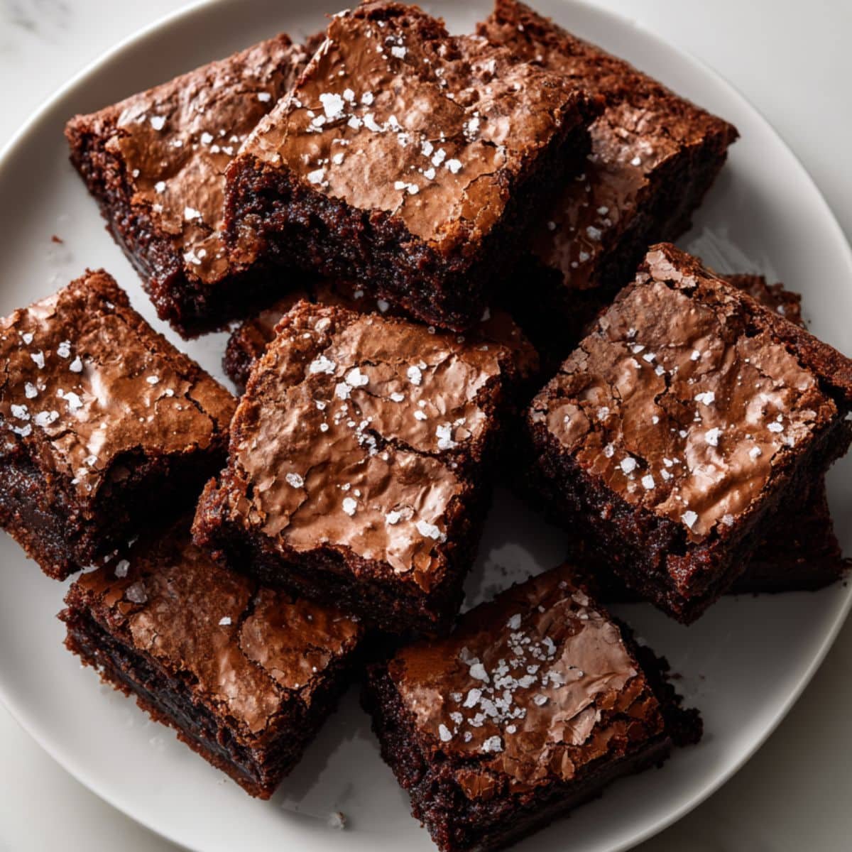 Freshly baked Nutella brownies cut into squares on white plate