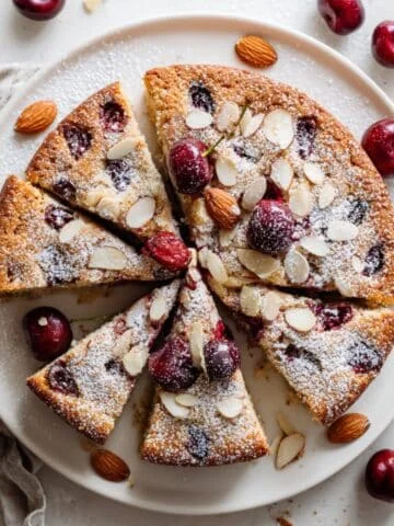 Cherry almond cake sliced on a white plate