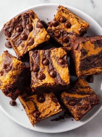 Homemade pumpkin brownies recipe with chocolate chips on a white plate