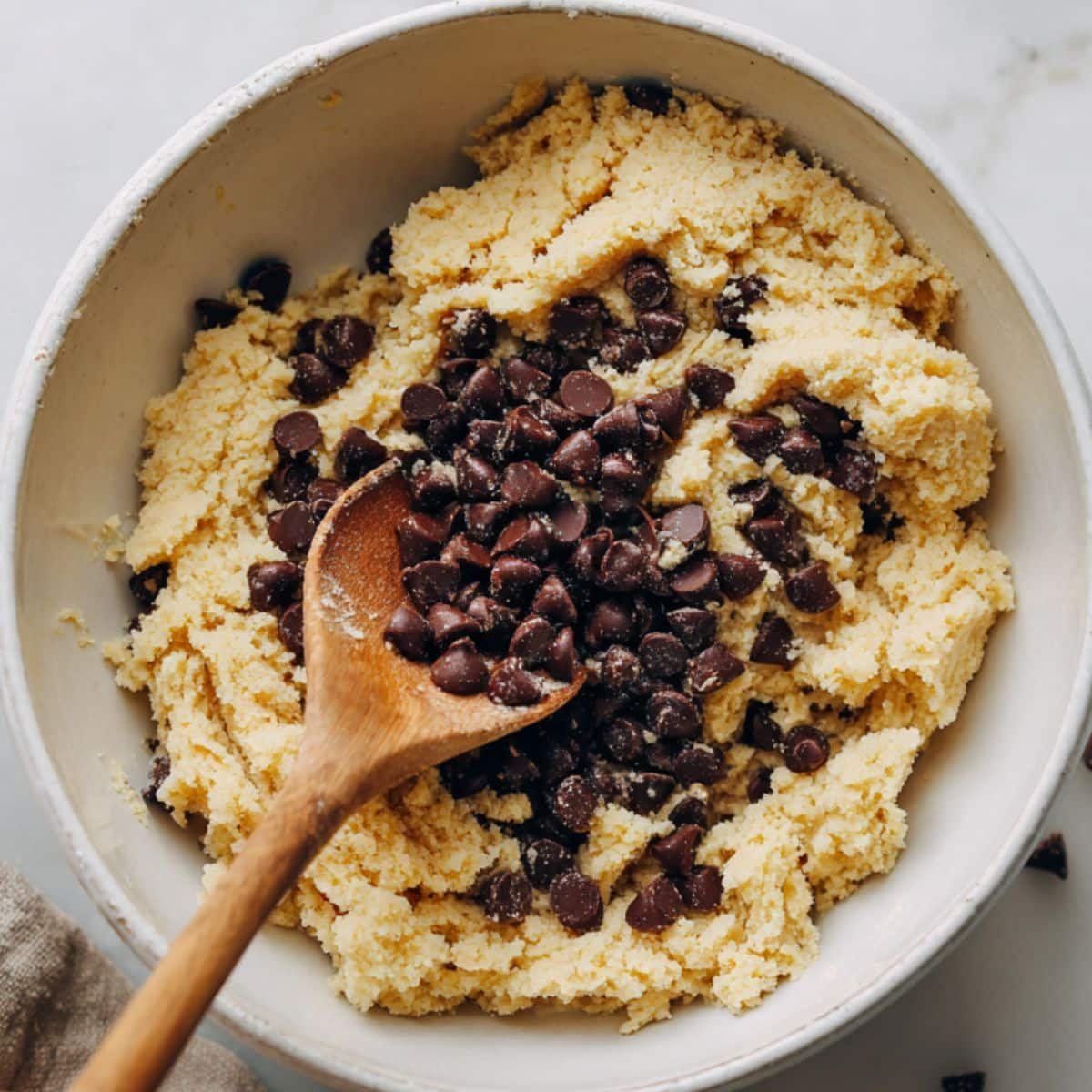 Mixing coconut oil, maple syrup, and vanilla in a bowl for almond flour cookie dough