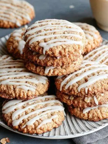 Frosted oatmeal cookies cooling on a rack with vanilla glaze