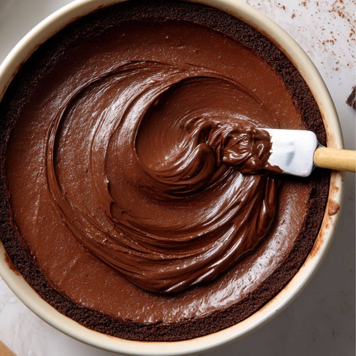 Mixing chocolate cheesecake filling in a bowl.	