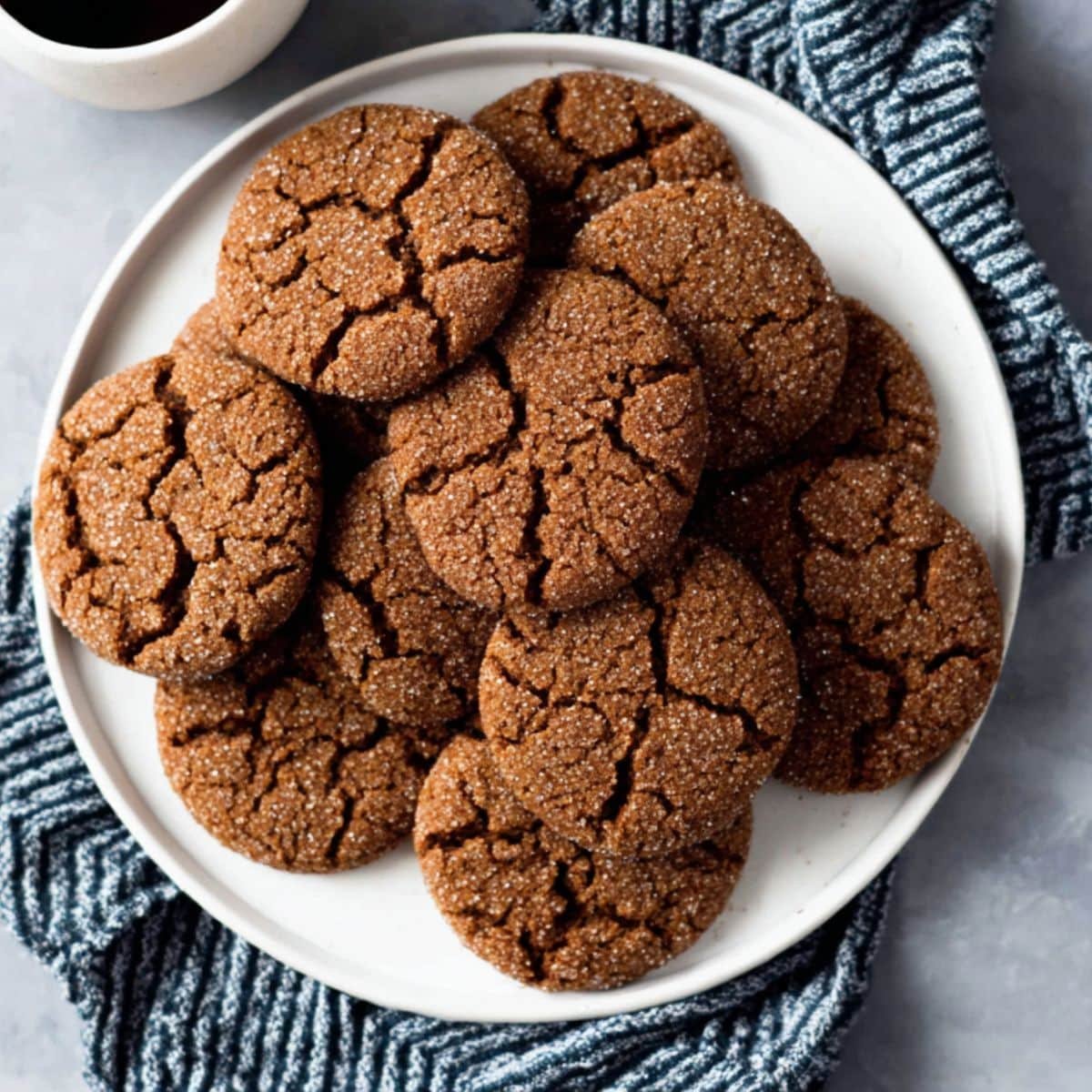 Crackled ginger molasses cookies on white counter
